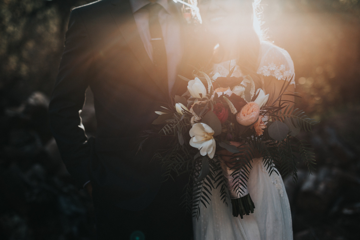 Image of a bride and groom holding a bouquet of flowers