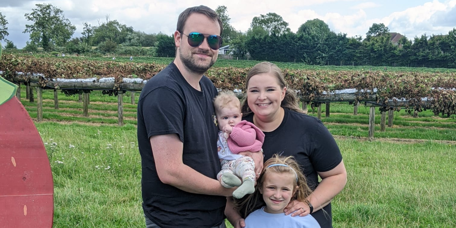 A family with the man holding a baby.