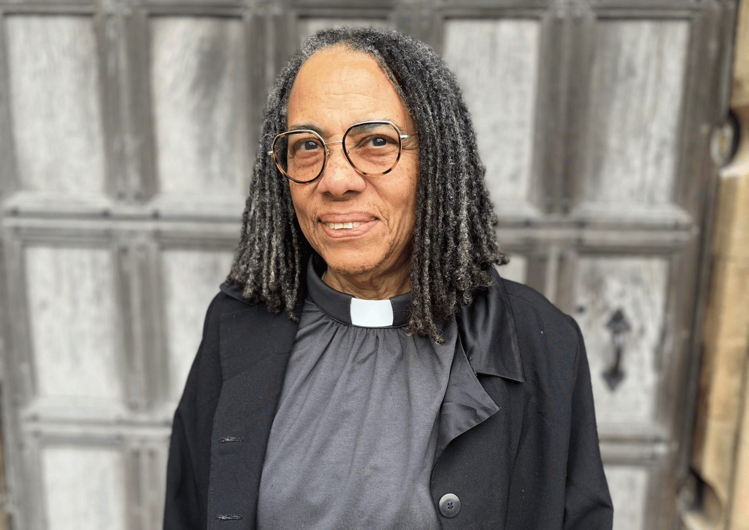 Rev'd Evie Vernon, Director for West Midlands Racial Justice Project stood in front of wooden door