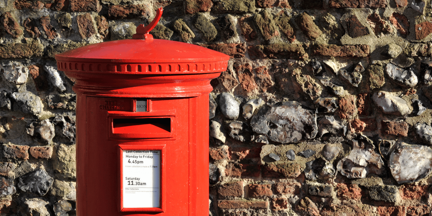 Red letter box against the backdrop of a brick wall