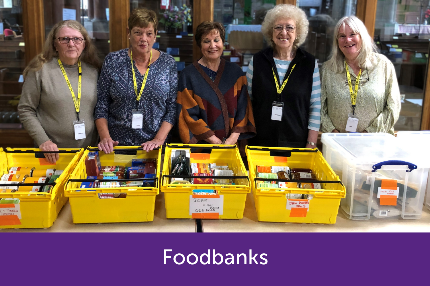 Foodbank helps stood behind boxes of food