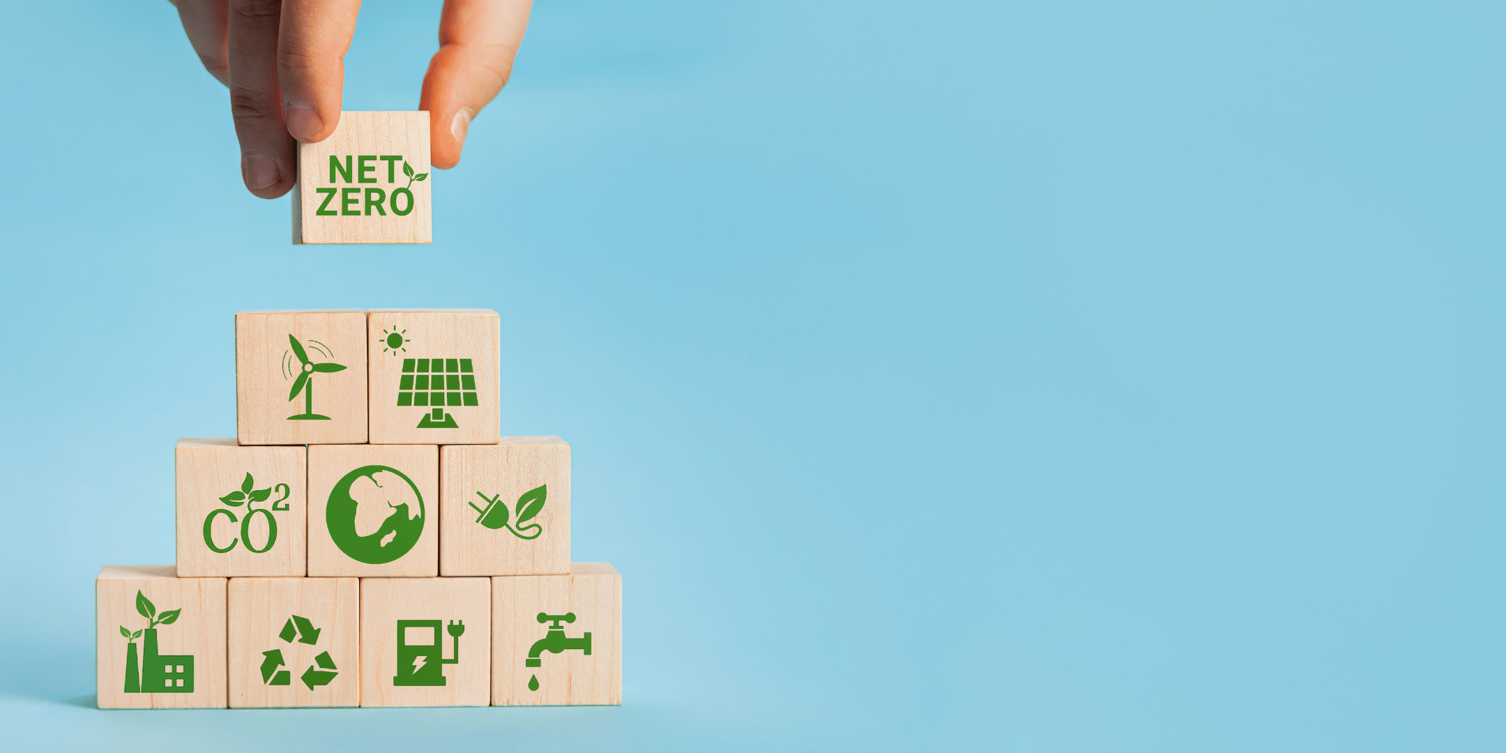 Hand placing a building block onto a stack of wooden blocks