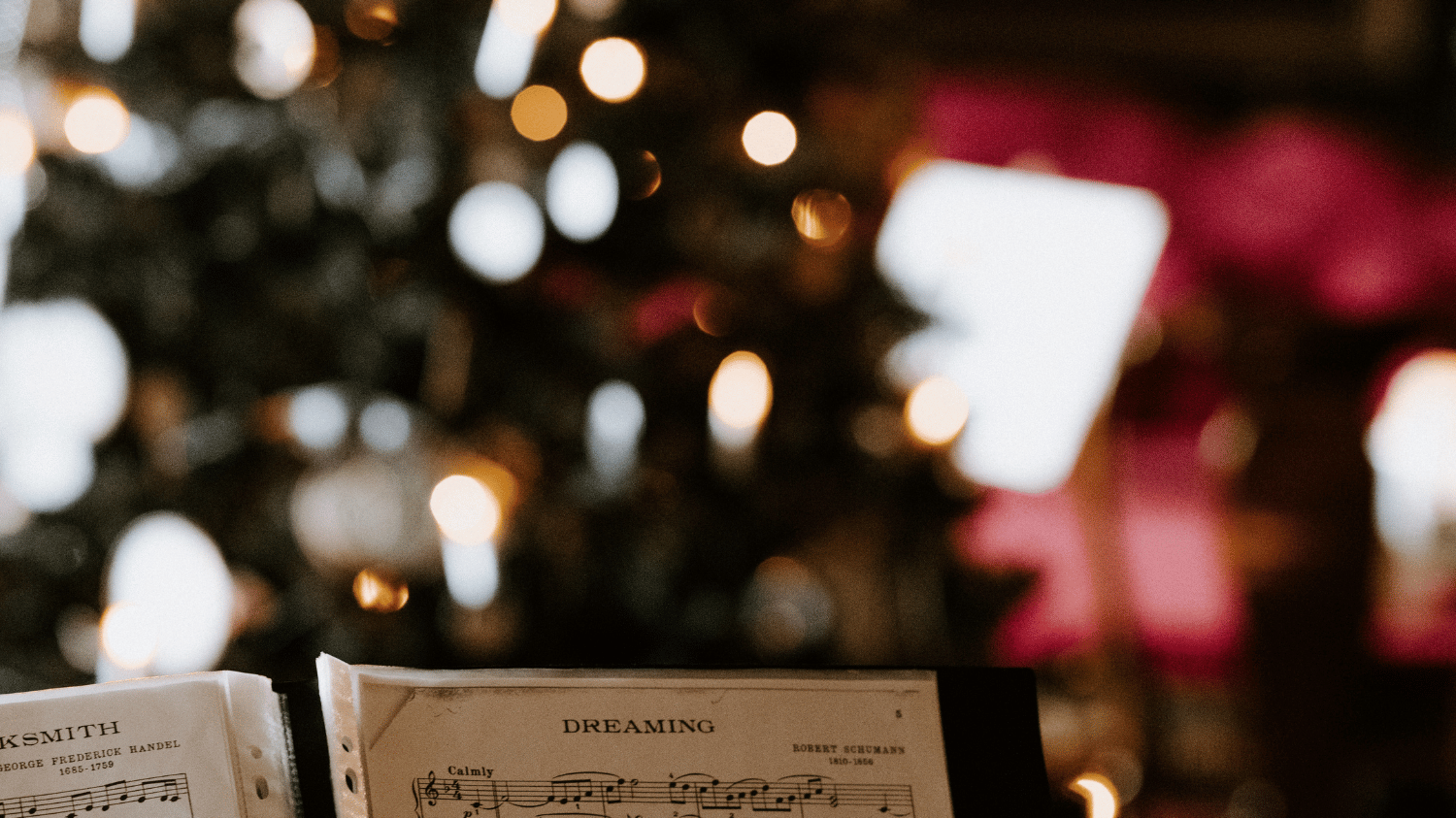 Stock image - Carol singing with soft focus Christmas tree in background