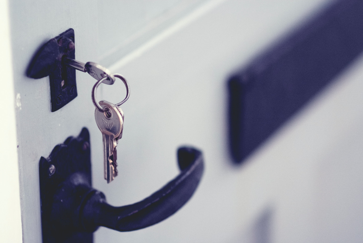 Image of a door being opened with a key