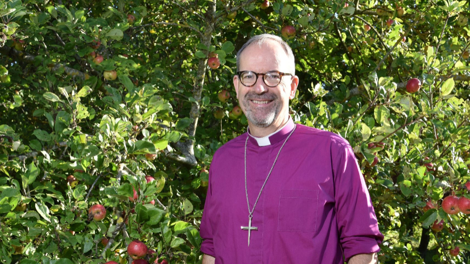 Image of Bishop Richard Jackson standing besides an apple tree