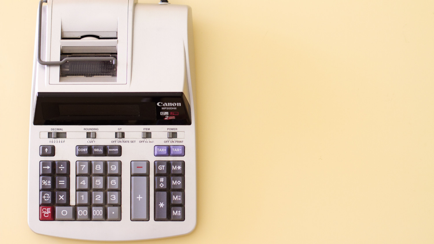 Image of an old accounting calculator on a bright yellow background