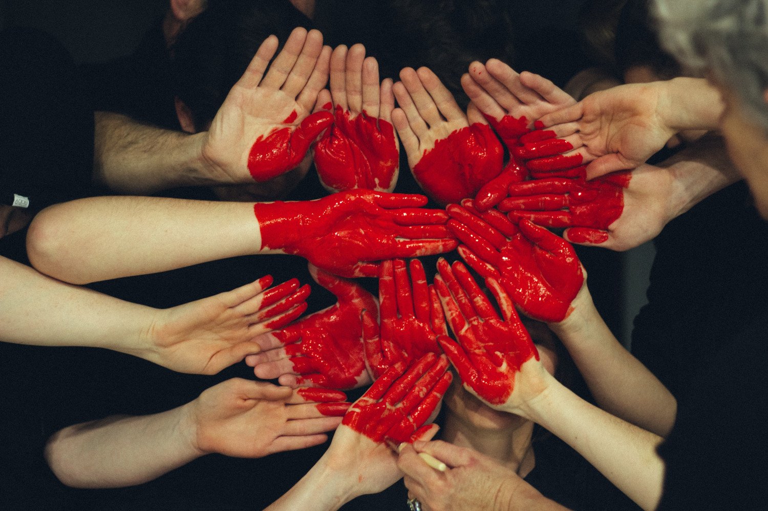 Image of a several hands with painted palms making up a heart shape