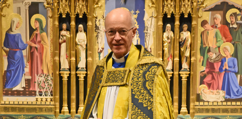 Image of Bishop Richard Jackson standing besides an apple tree