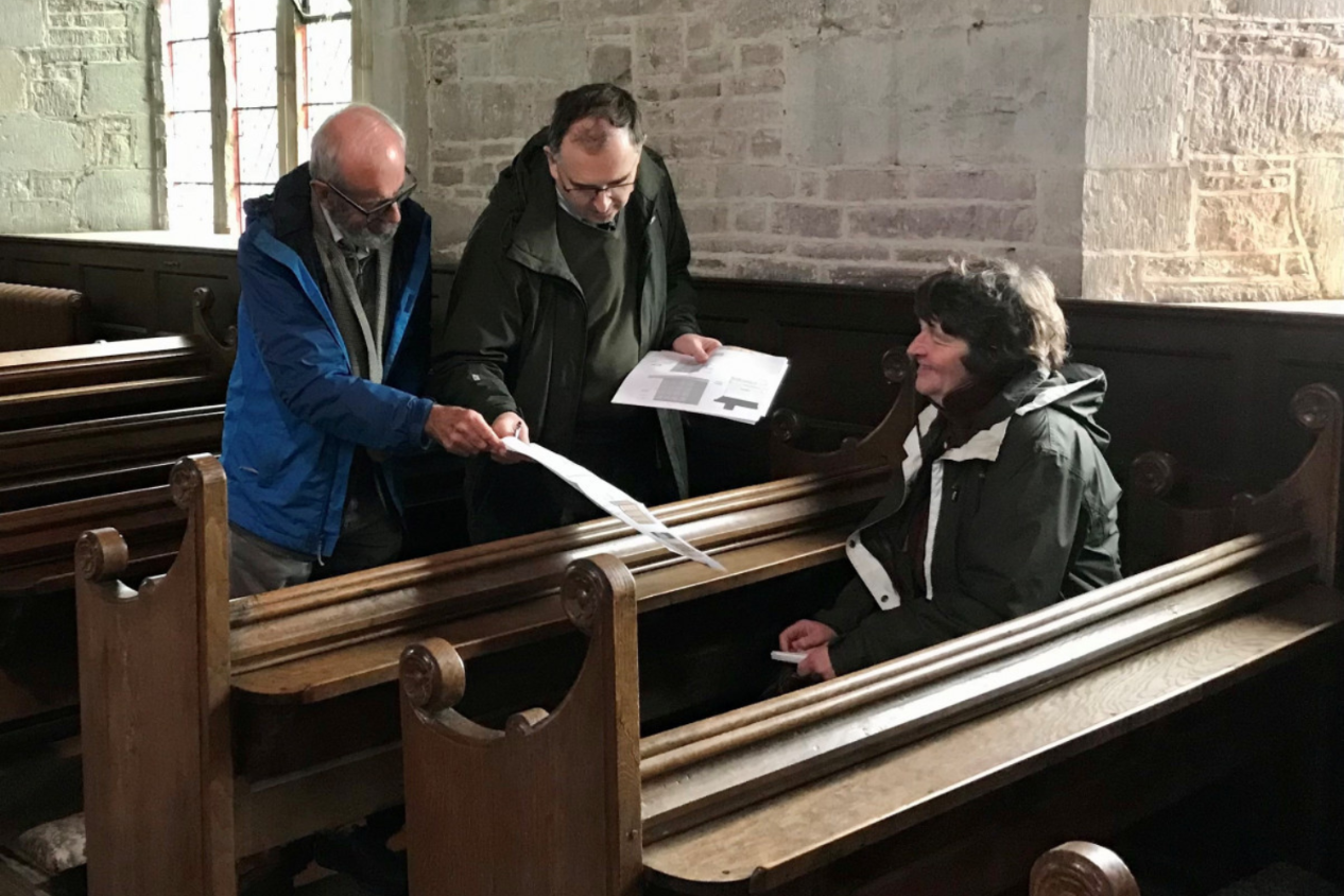 People inspecting a Church pew