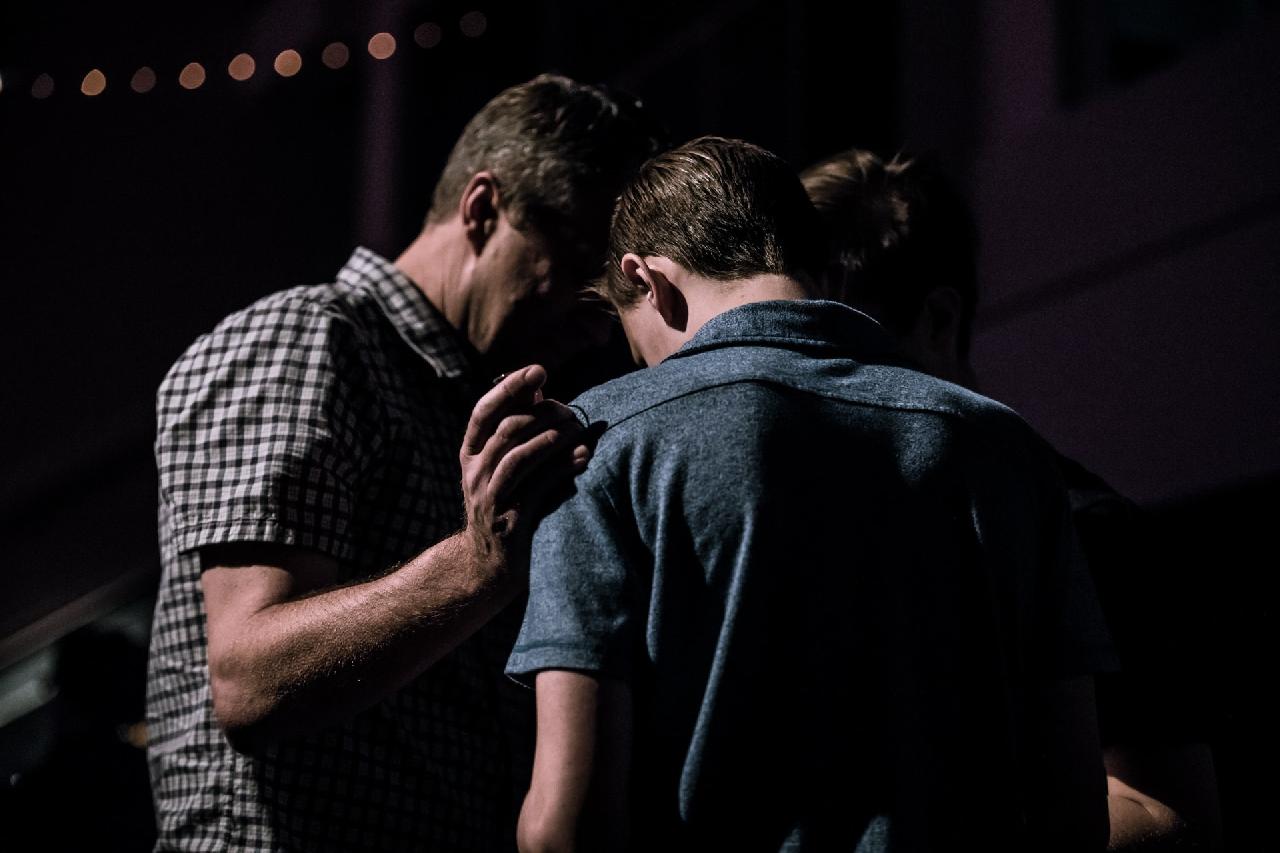 image of older person praying with younger person